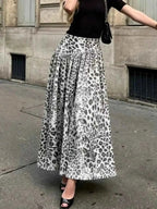 Animal Print Maxi Skirt in white and black with leopard pattern, flowing polyester fabric, worn with black top and heels