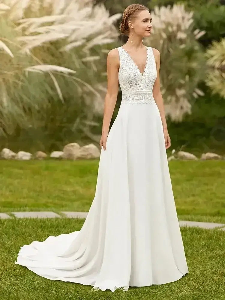 Beach Wedding Dress featuring delicate white lace bodice with V-neckline and flowing lightweight skirt with a court train