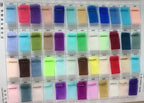 Fabric swatches in various colors and textures on a sample card, showcasing shades from blue and purple to green and brown