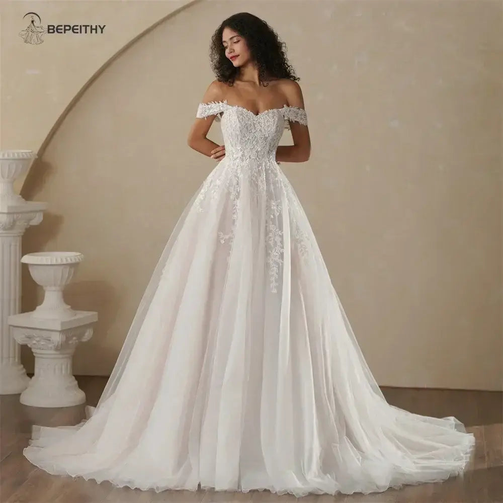 Boho Champagne Wedding Dress featuring an off-shoulder neckline, delicate lace appliques, and a flowing A-line skirt