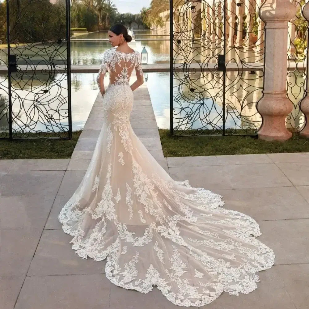 Boho Mermaid Wedding Dress in ivory with sheer long sleeves, intricate lace appliques, and a dramatic court train