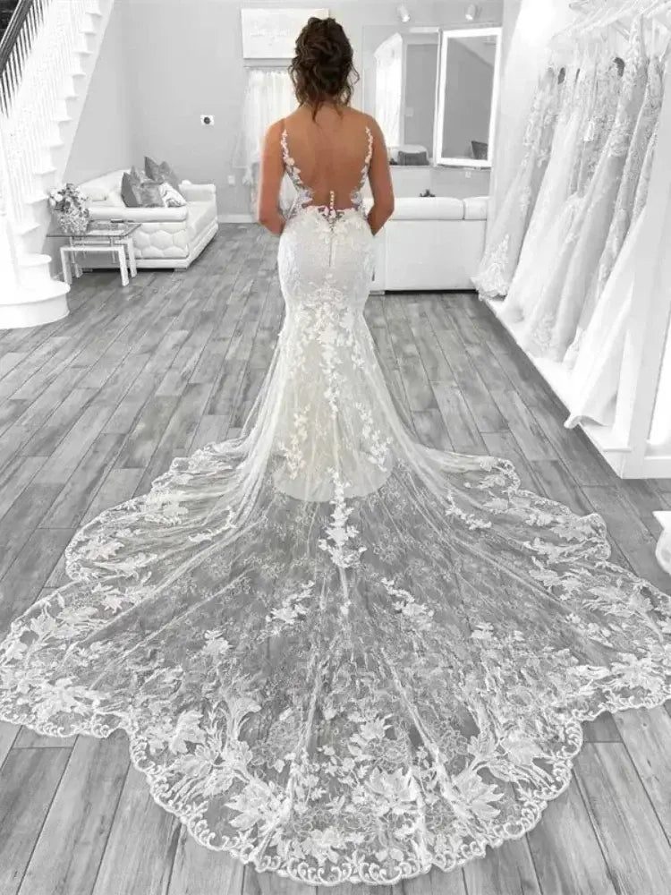 Boho Mermaid Wedding dress in white lace with appliques, open back, spaghetti straps, and a long scalloped train