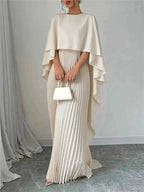 Cape Pleated Maxi Dress in cream polyester featuring a flowing cape overlay and finely pleated maxi skirt detail.