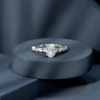 Silver engagement ring featuring a Carat IGI Certified Oval Diamond center stone with round and marquise side stones on a sleek band