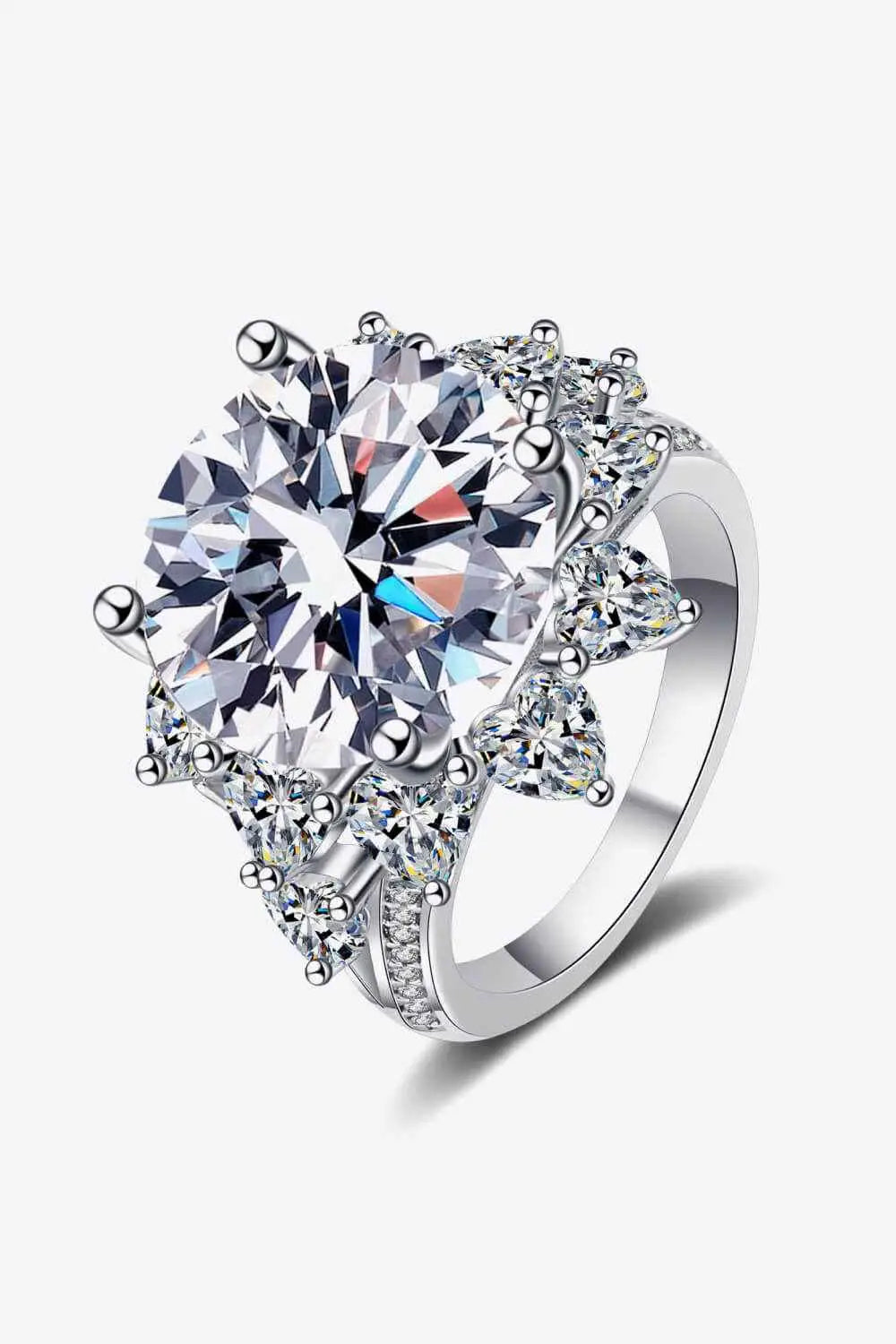 Flower-shaped silver ring with a large round Carat Moissanite center stone and smaller triangular accent stones in a polished setting