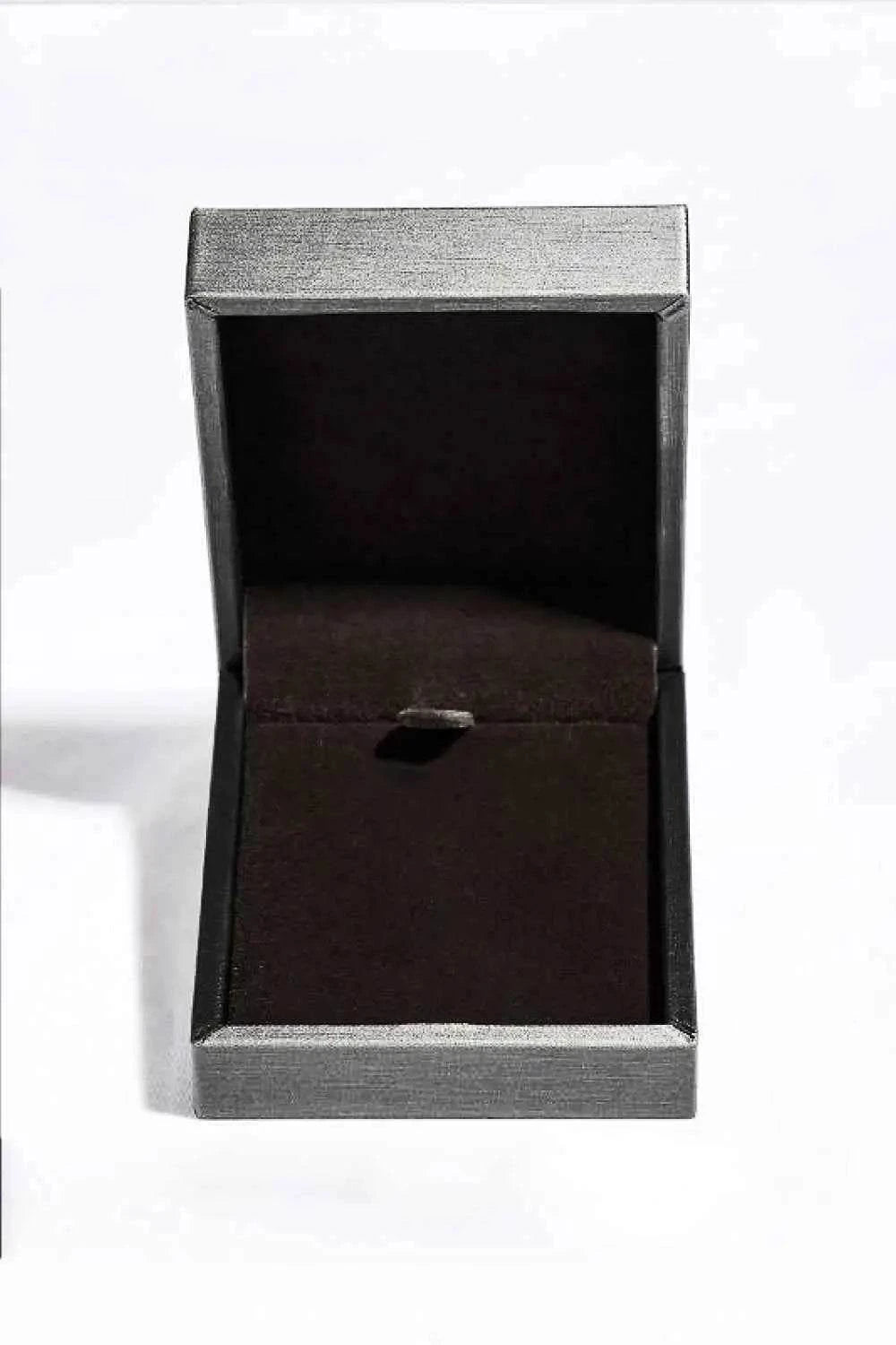 Empty rectangular silver-tone jewelry box with dark velvet interior designed to hold a Carat Moissanite necklace