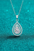 Carat Moissanite Teardrop Pendant necklace with a 1 carat pear-shaped moissanite center stone surrounded by smaller accent stones on a silver chain