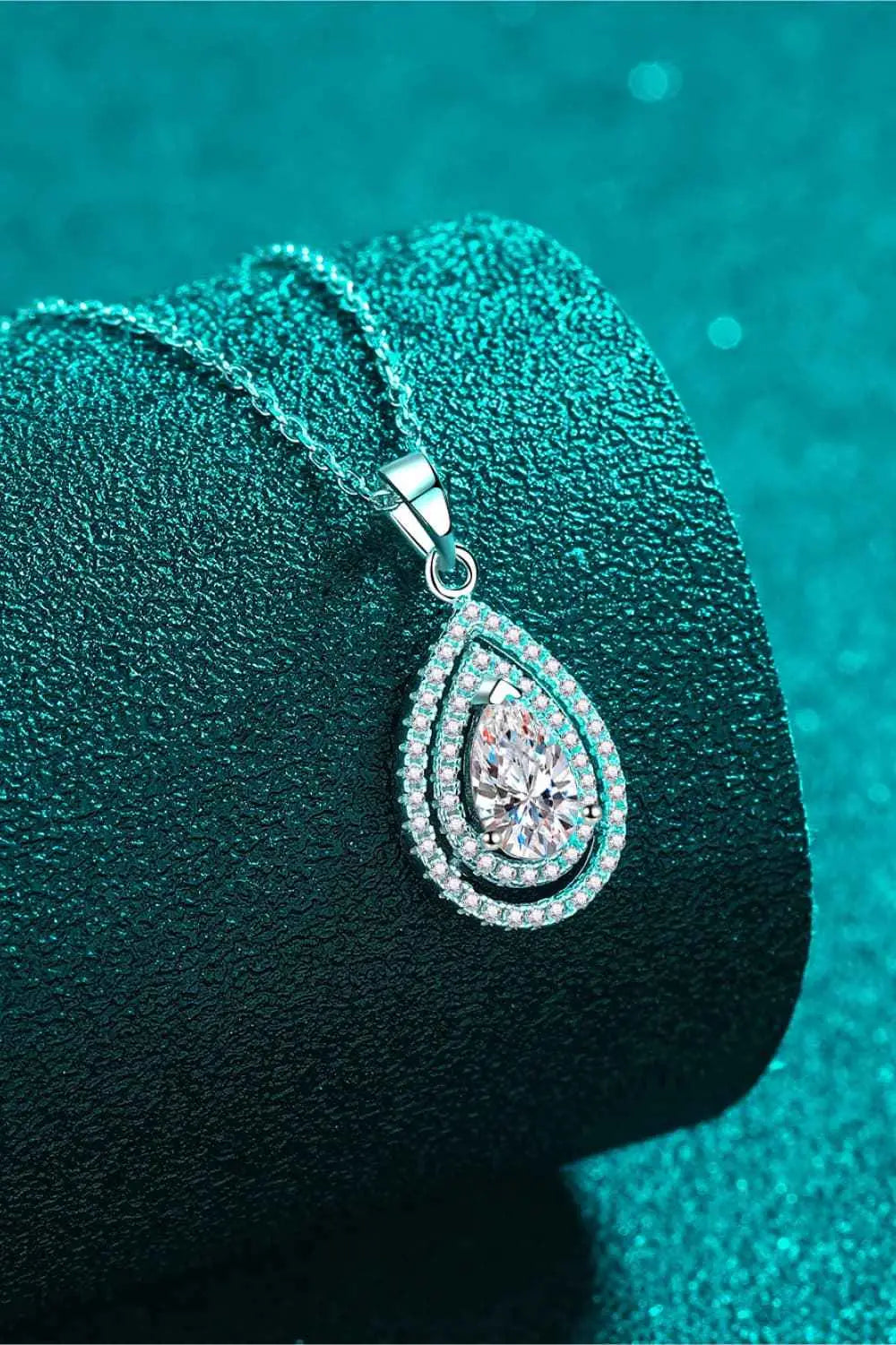 Carat Moissanite Teardrop Pendant in silver with a pear-shaped central stone surrounded by smaller accent stones on a fine chain