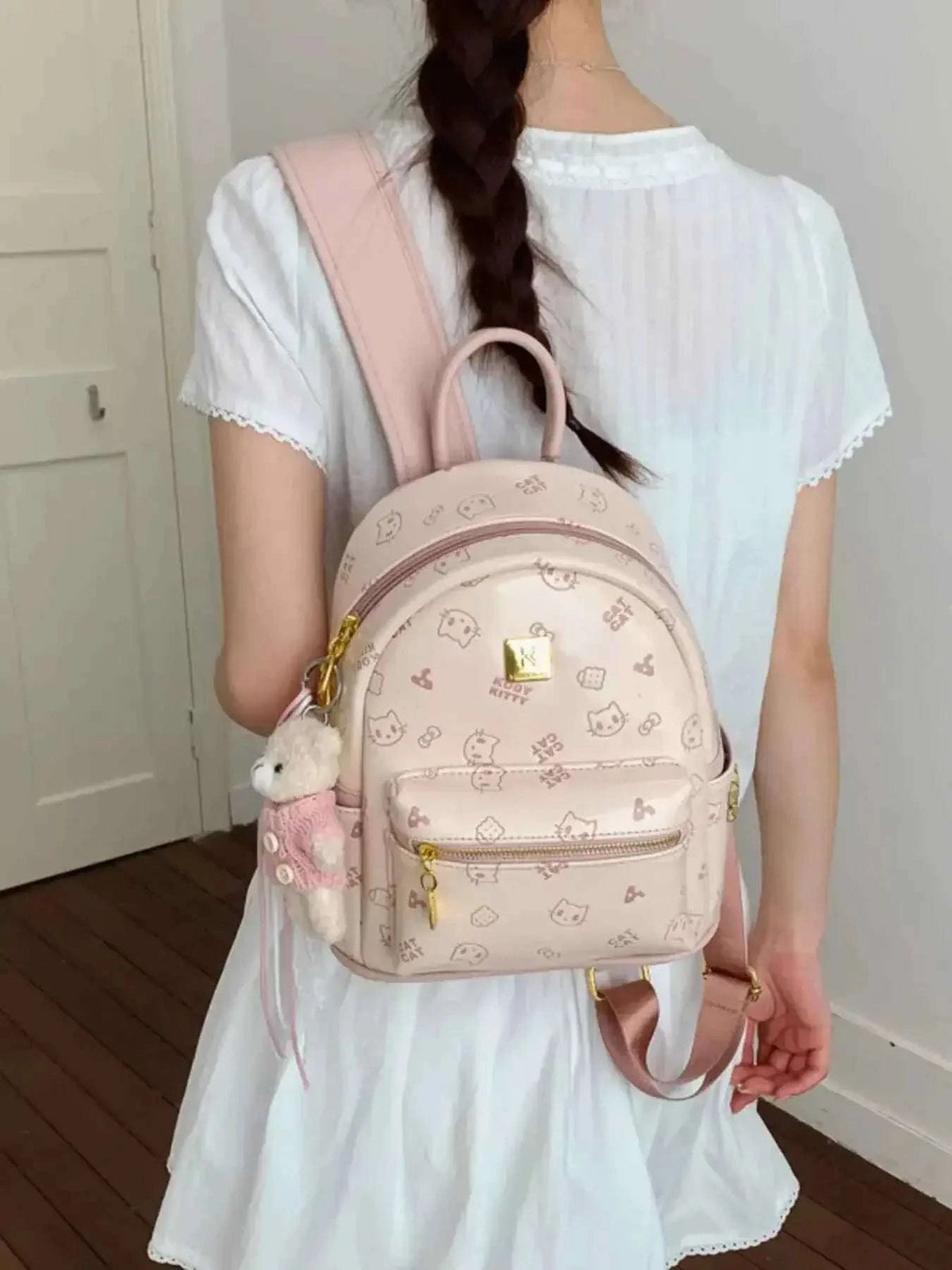 Mini cartoon pattern backpack in soft pink PU leather with bear pattern, gold zipper, and bear pendant charm