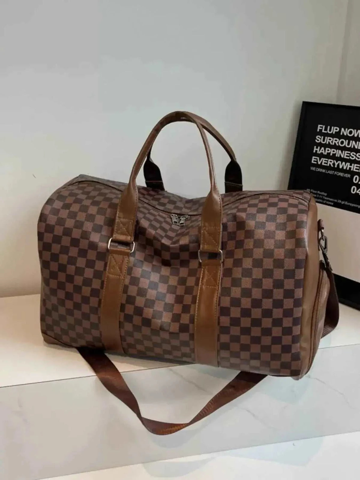 Large checkered pattern travel bag in brown PU leather with dark brown handles and adjustable shoulder strap