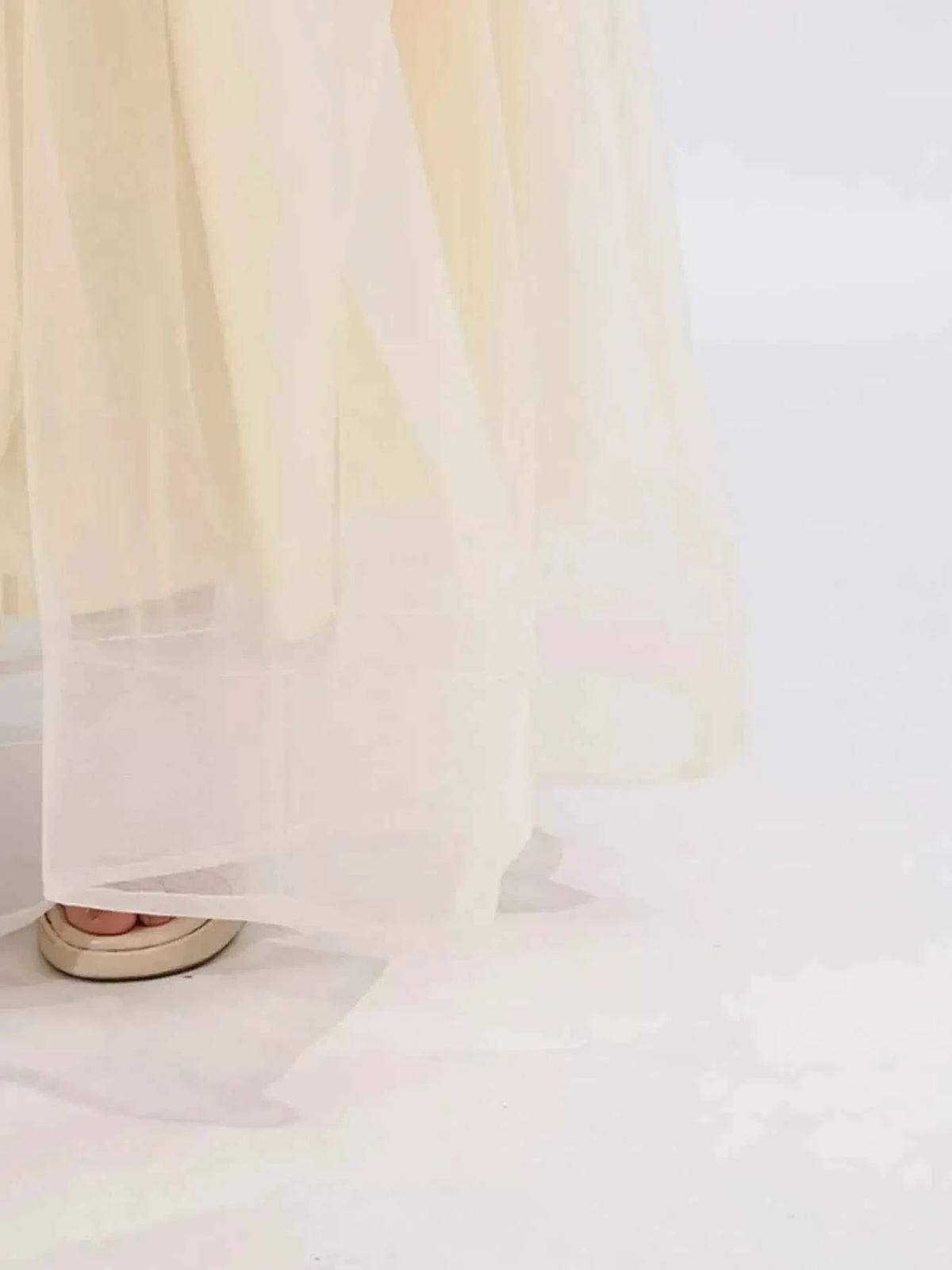 Contrast Flower Sleeveless sheer ivory tulle maxi dress hem with visible lining and layered fabric detail