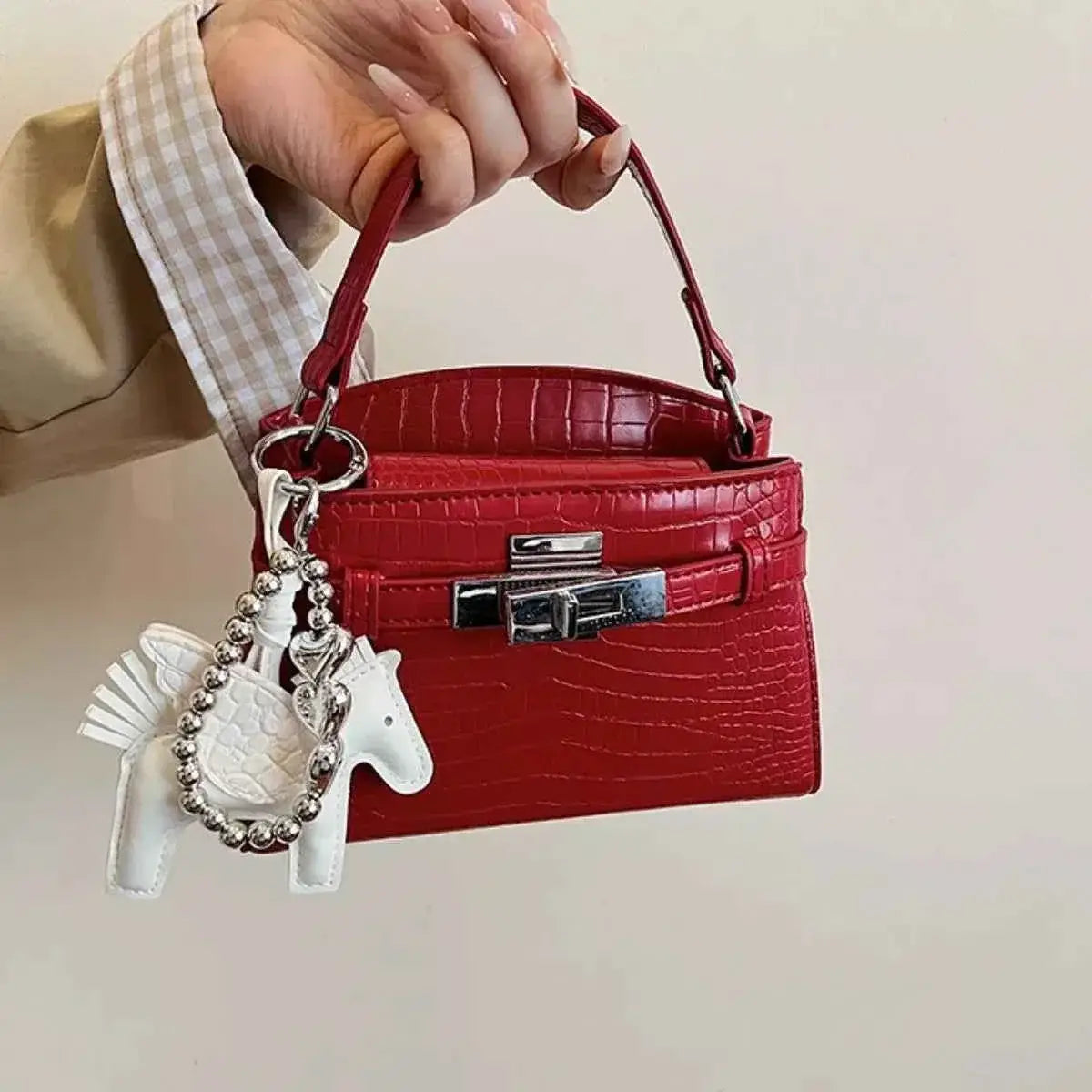 Crocodile-Embossed mini top-handle handbag in red PU leather with silver-tone hardware and white horse keychain