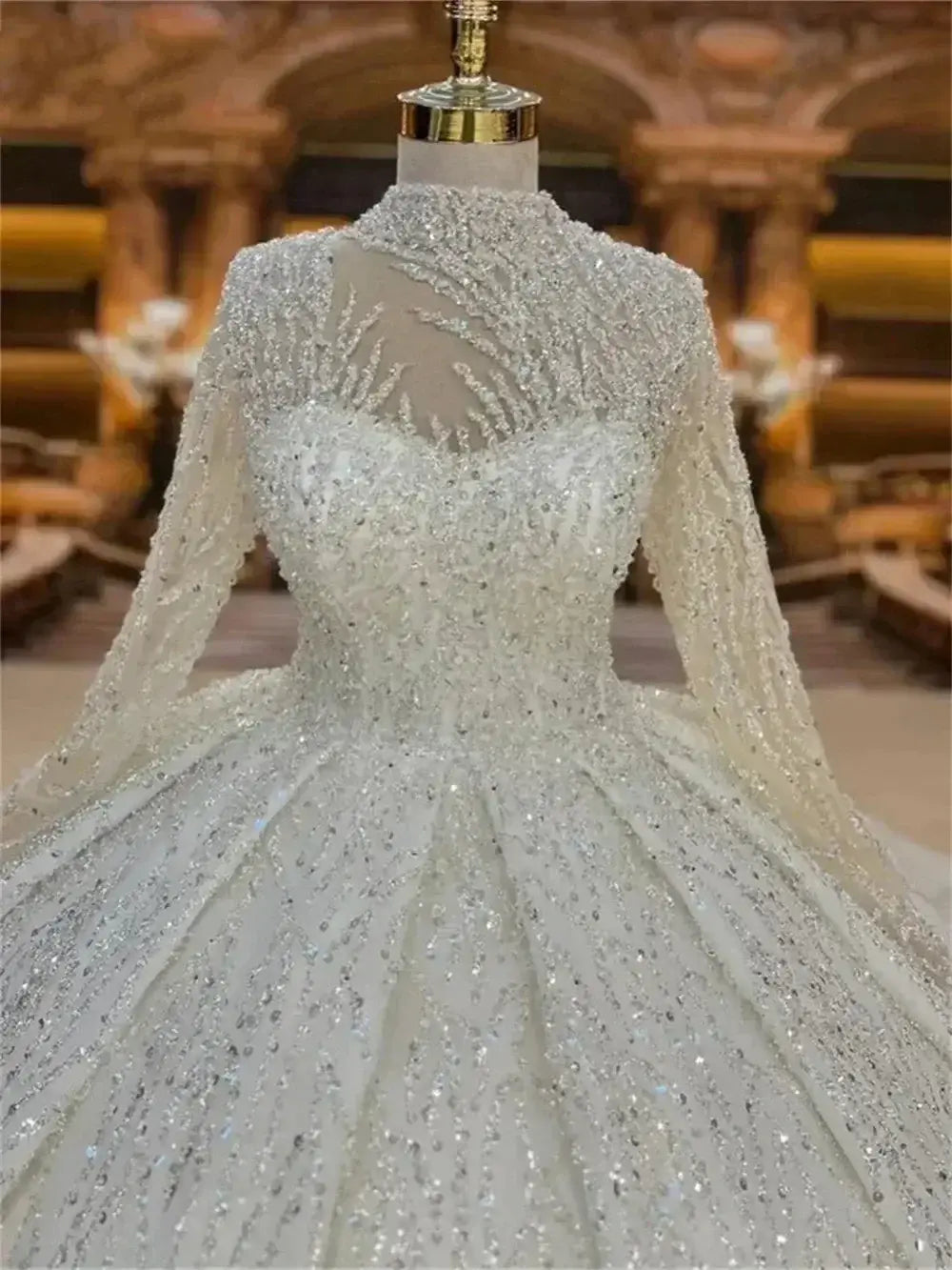 Custom High Neck Ball Gown featuring intricate beading, pearls, lace fabric, long sleeves, and a sheer embellished high neckline