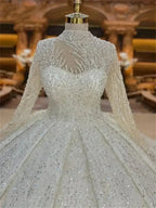 Custom High Neck Ball Gown featuring intricate beading, pearls, lace fabric, long sleeves, and a sheer embellished high neckline