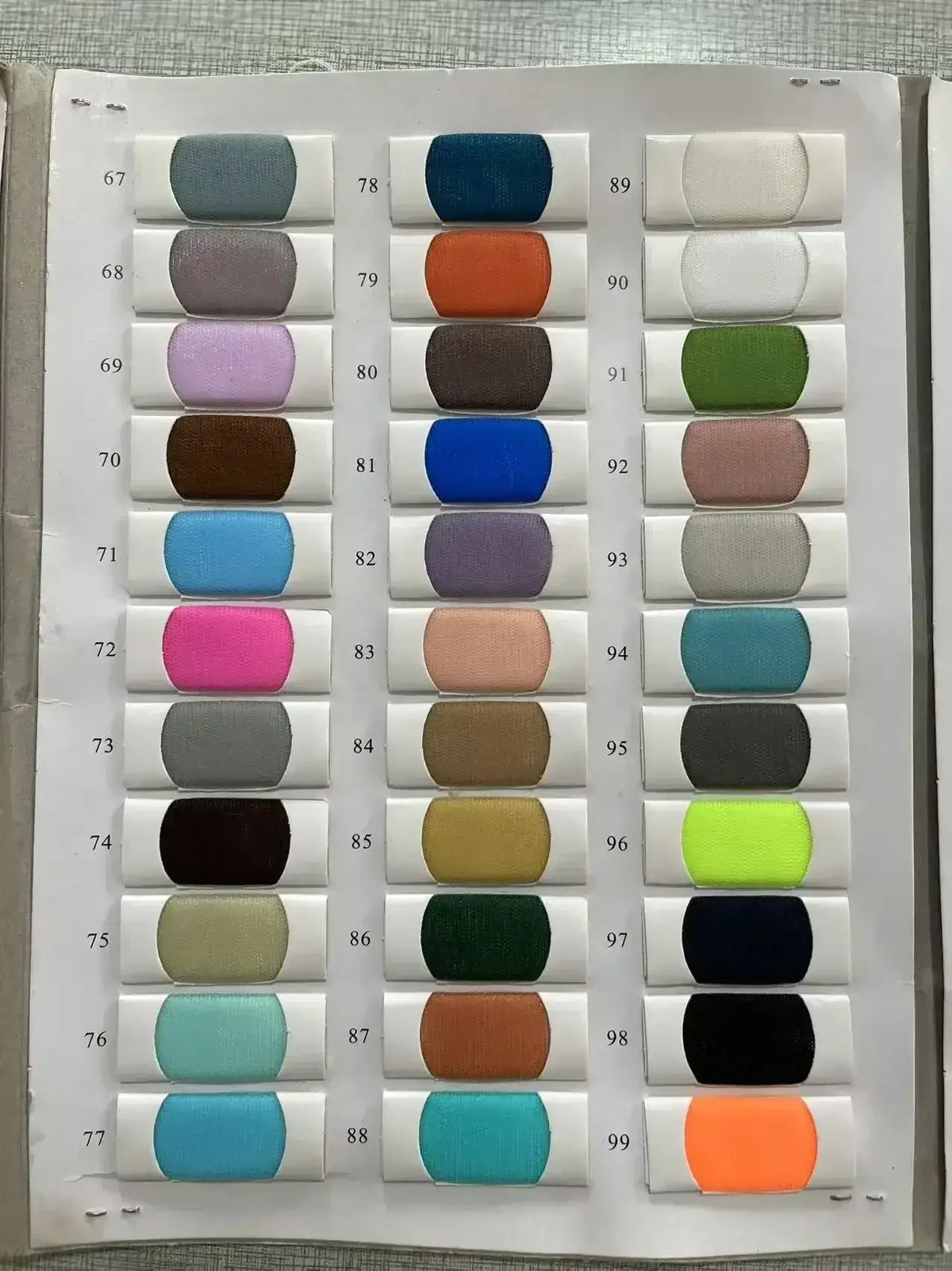 Range of fabric swatches in various solid colors, ideal for customizing a Custom High Neck Ball Gown design.