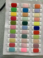 Fabric color swatches in shades of red, green, yellow, blue, pink, purple, and brown arranged in rows with white backing cards for Customized Wedding Dresses.