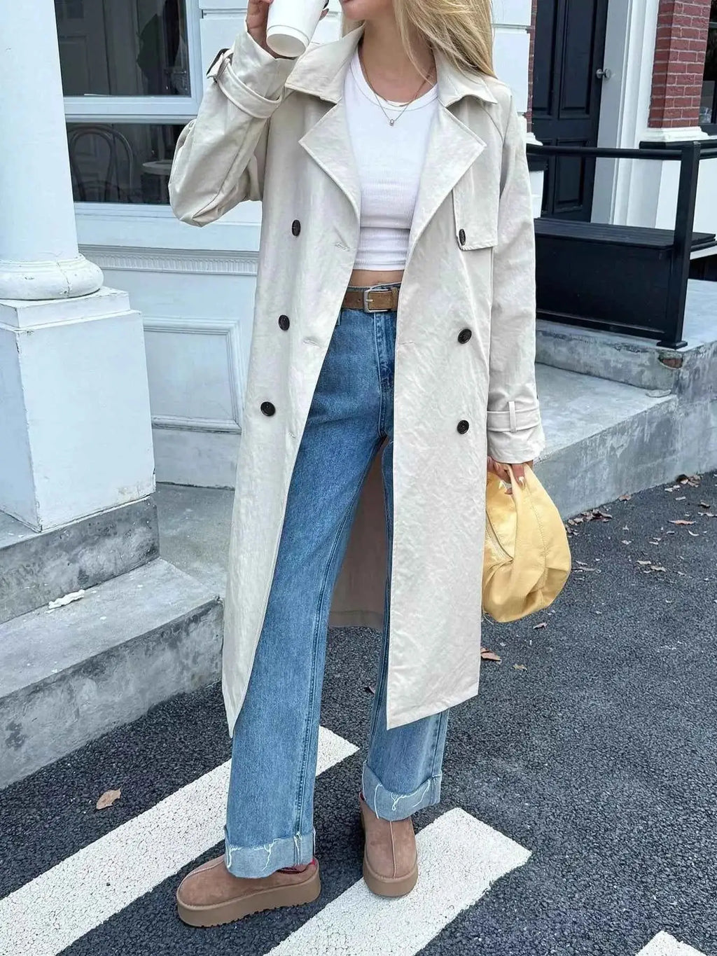 Double-Breasted Belted Trench Coat in beige polyester with buttoned front, belt at waist, and classic lapels