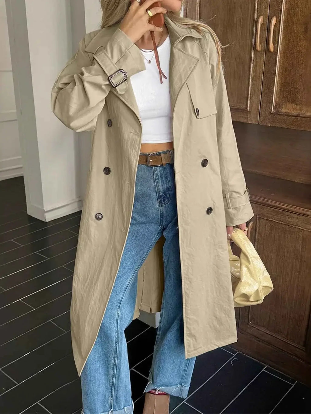Double-Breasted Belted Trench Coat in beige polyester with buttoned front, belt at waist, and cuff straps