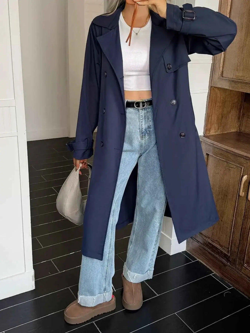 Double-Breasted Belted Trench Coat in navy blue polyester with buttons, belt, and long sleeves styled with casual jeans and boots