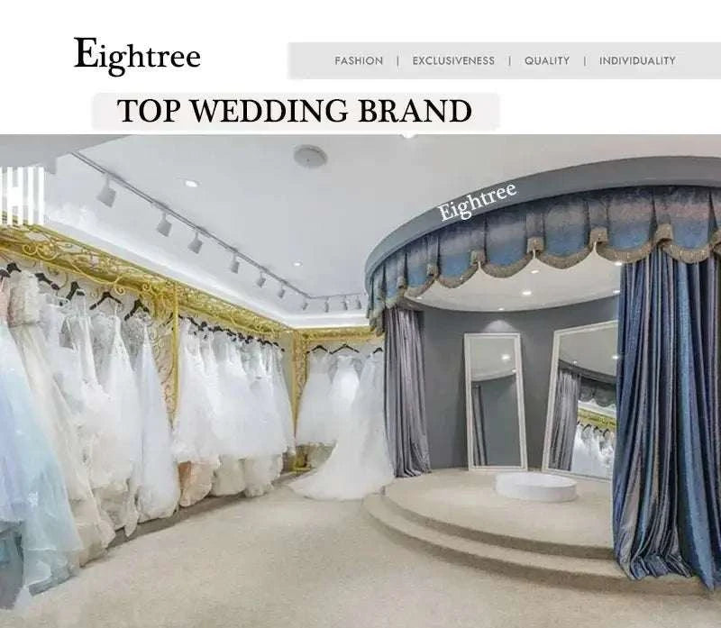 Wedding boutique interior with elegant white wedding gowns hanging along golden-trimmed walls and a circular blue velvet curtained fitting area