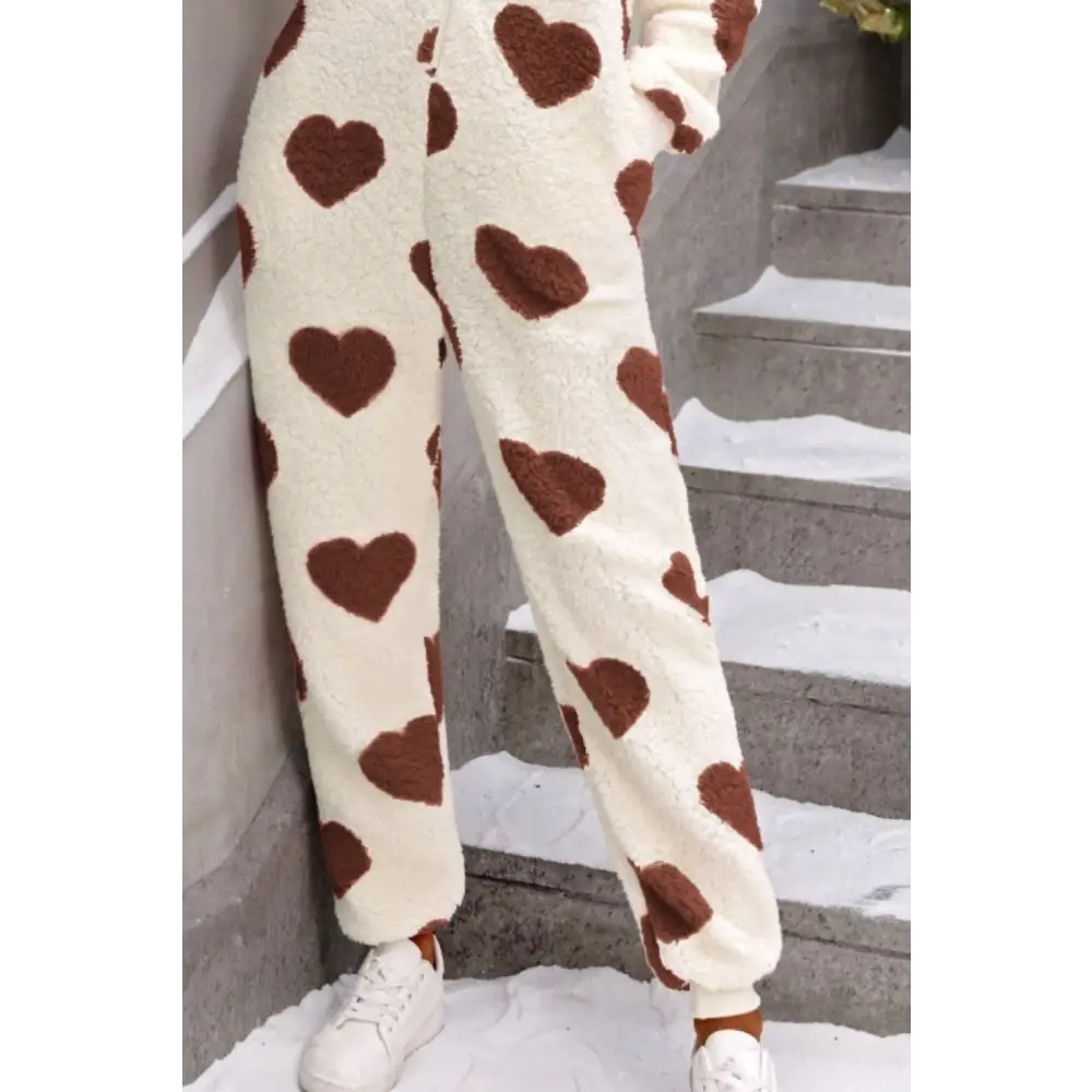 Elevate your wardrobe with the fuzzy heart zip up hooded lounge jumpsuit $35.99 this exquisite piece embodies a basic