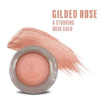 A shimmering rose gold gilded rose waterproof multi-tasking creme-to-powder product in a clear jar with silver lid