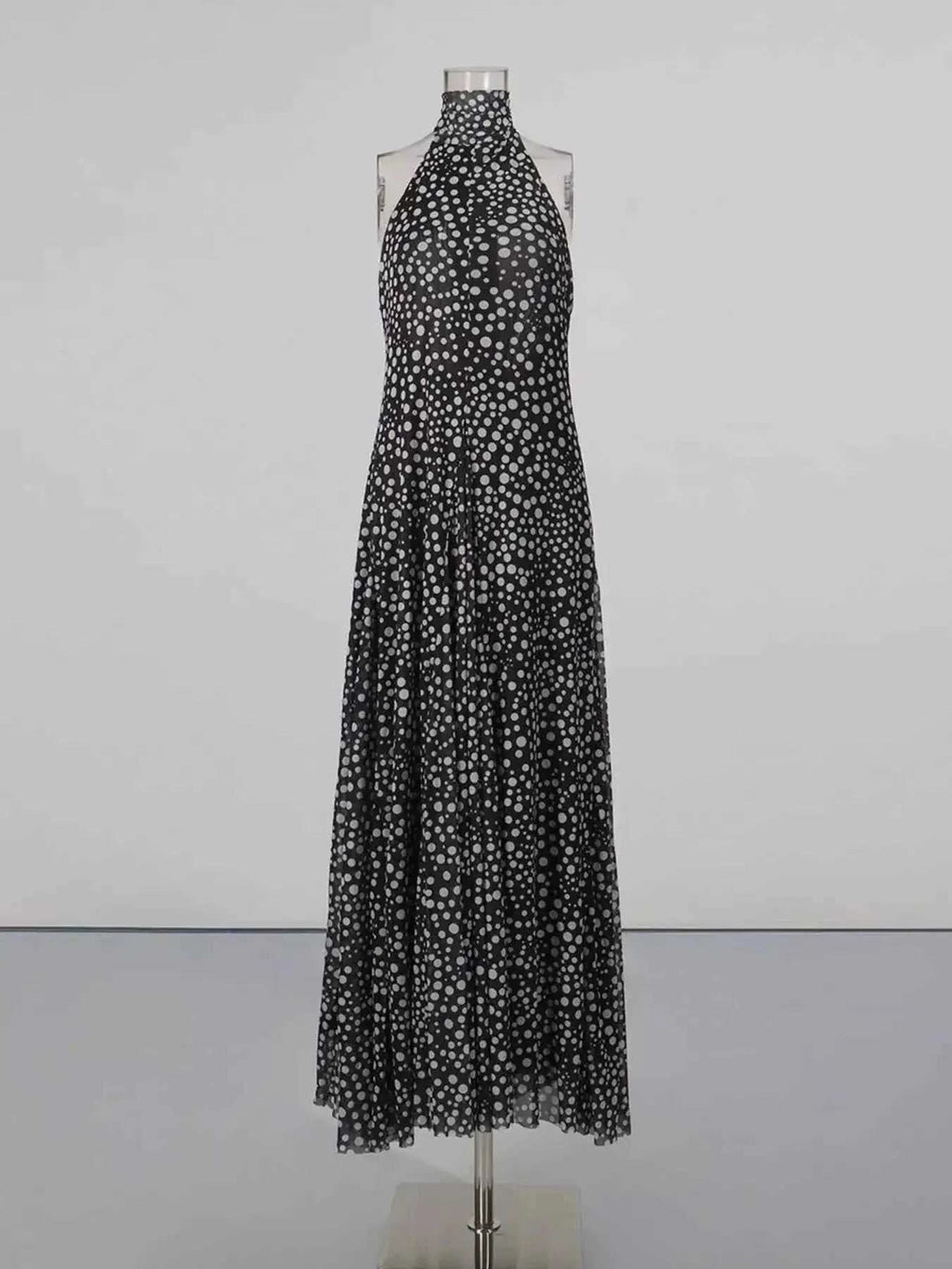 Halter Neck Polka Dot maxi dress in black with white polka dots, halter neck tie, and flowy full-length skirt