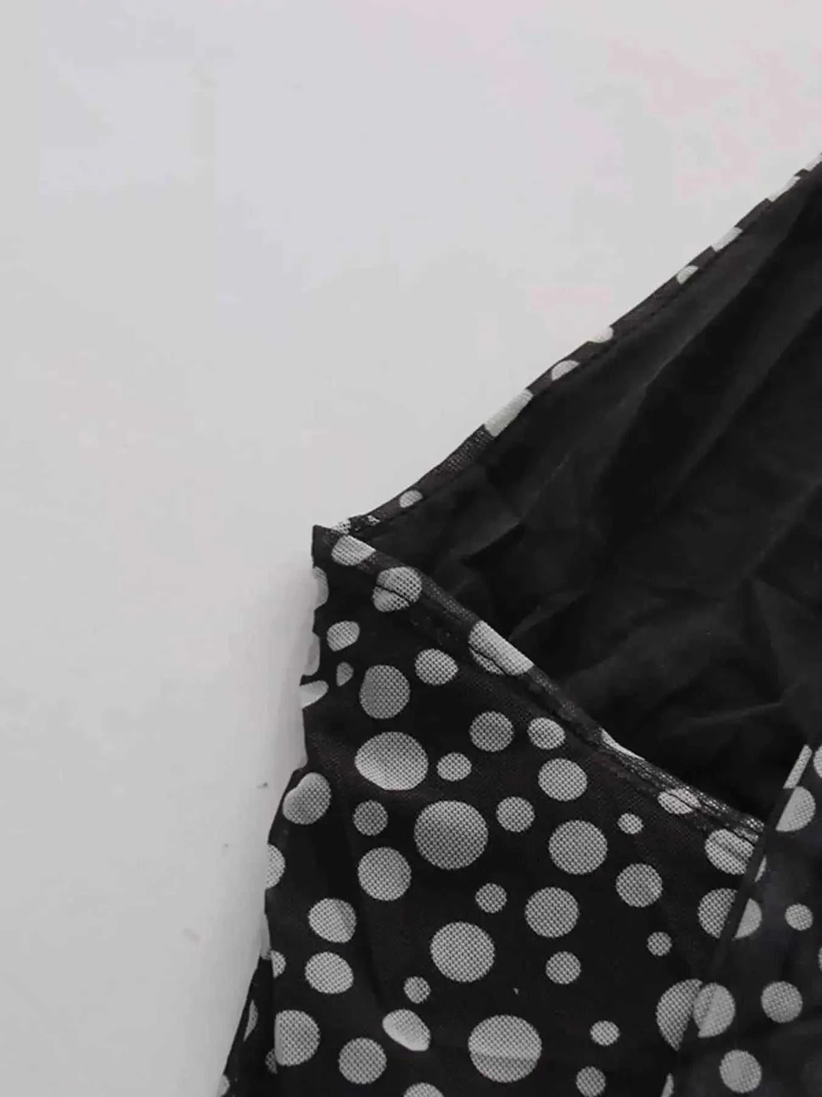 Halter Neck Polka Dot black and white sleeveless dress with various sized polka dots and tied halter neckline