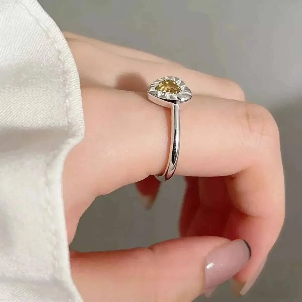 Heart-Shaped Open Ring in polished silver with a yellow gemstone centerpiece and an open adjustable band design.
