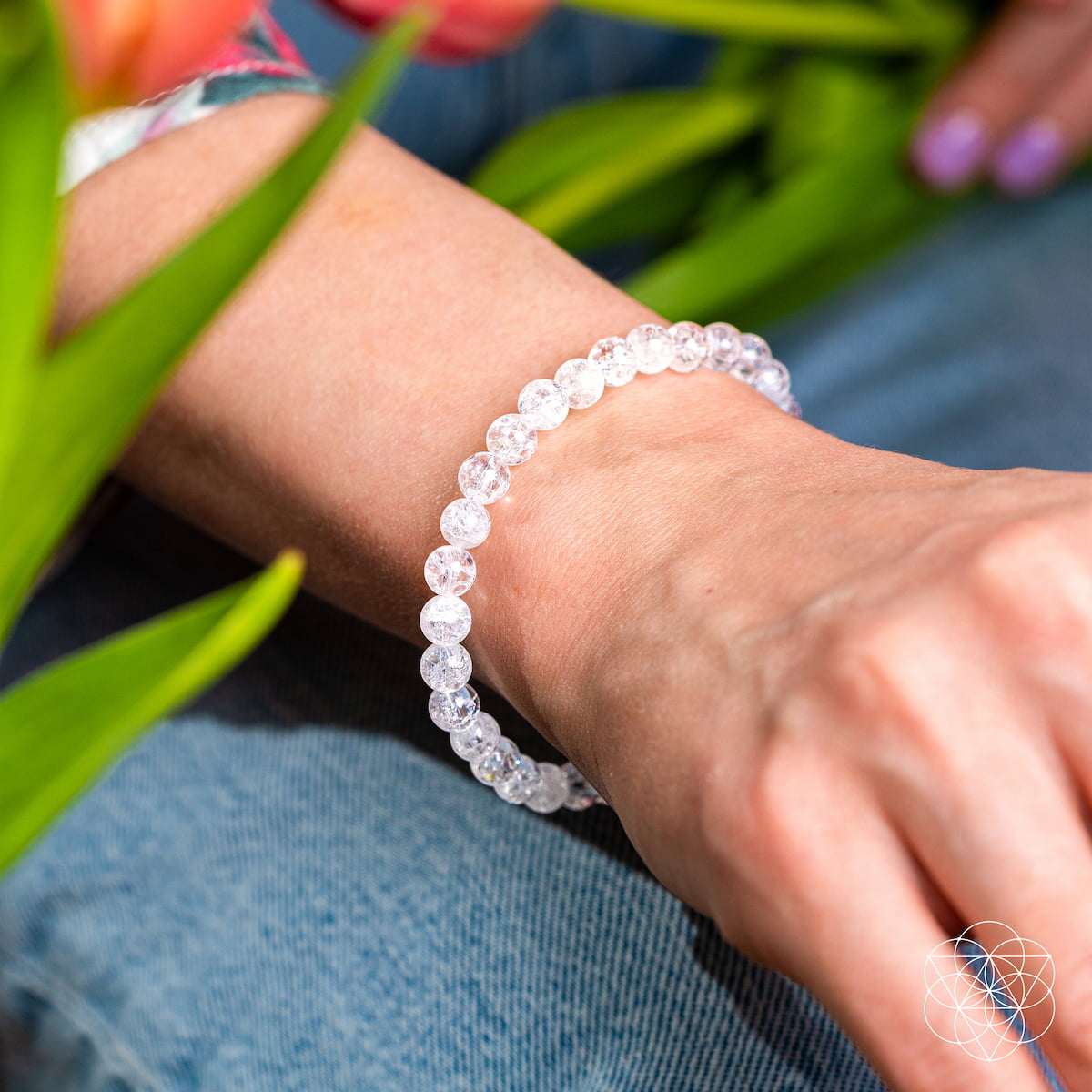 Ice Quartz bracelet with 6mm clear round beads featuring natural internal fractures worn on wrist, shimmering like frozen light