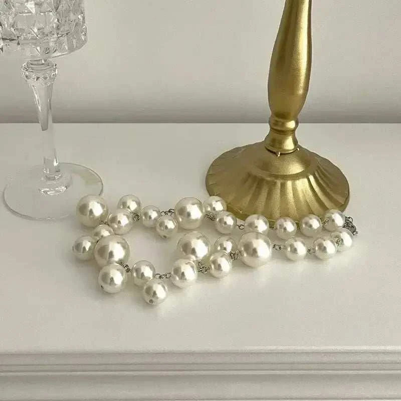 Imitation Pearl Women's Necklace with large and small round white beads arranged as a choker with a silver clasp