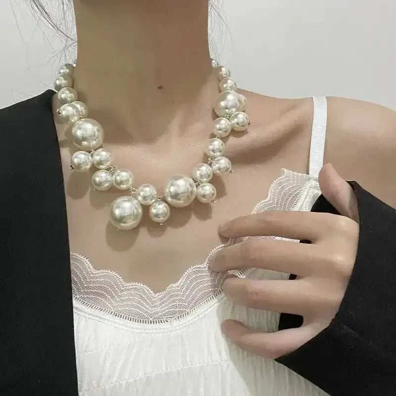 Imitation Pearl Women's Necklace featuring large white round simulated pearls in a choker design worn over white lace-trimmed top