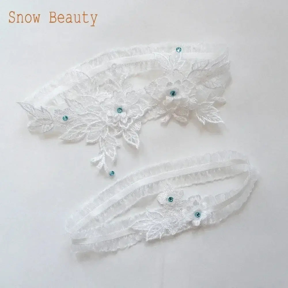 White wedding garter belt set with floral lace applique and small blue crystals, delicate and romantic design