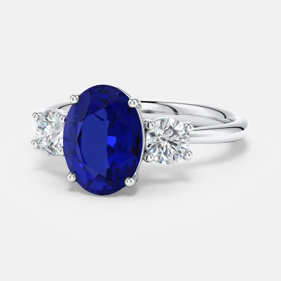 Lab-Grown Blue Sapphire oval-cut blue sapphire center stone with two round brilliant diamonds set in polished 14K white gold