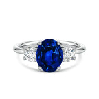 Lab-Grown Blue Sapphire oval center stone engagement ring with two round diamonds set in polished 14K white gold