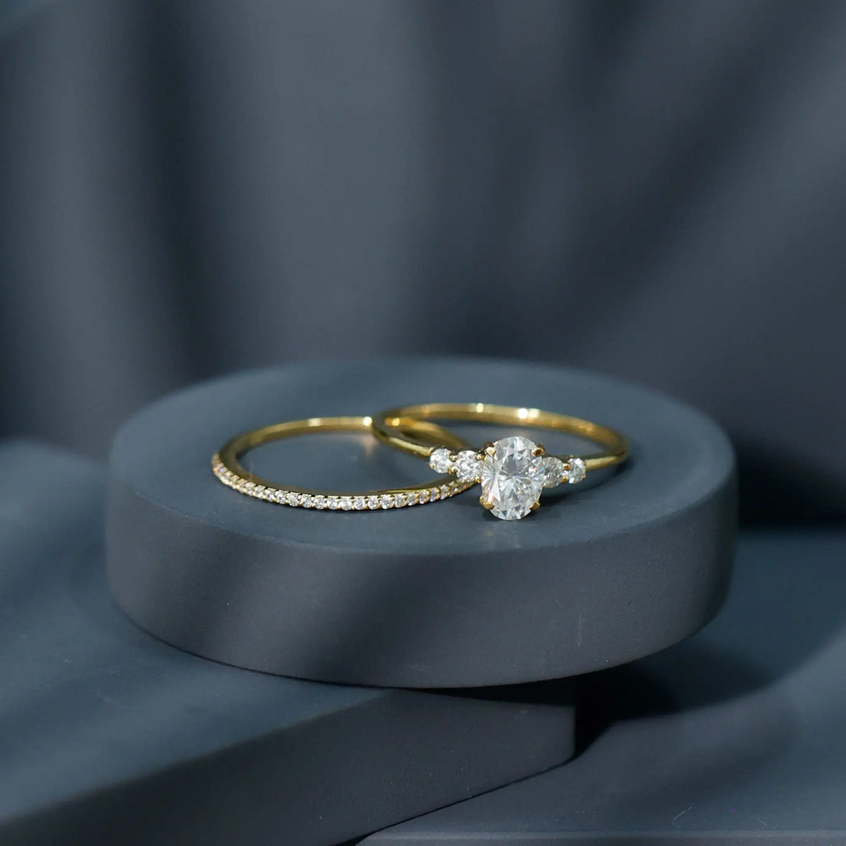 Lab Grown Diamond oval cut engagement ring with round side stones and matching gold wedding band with small diamonds