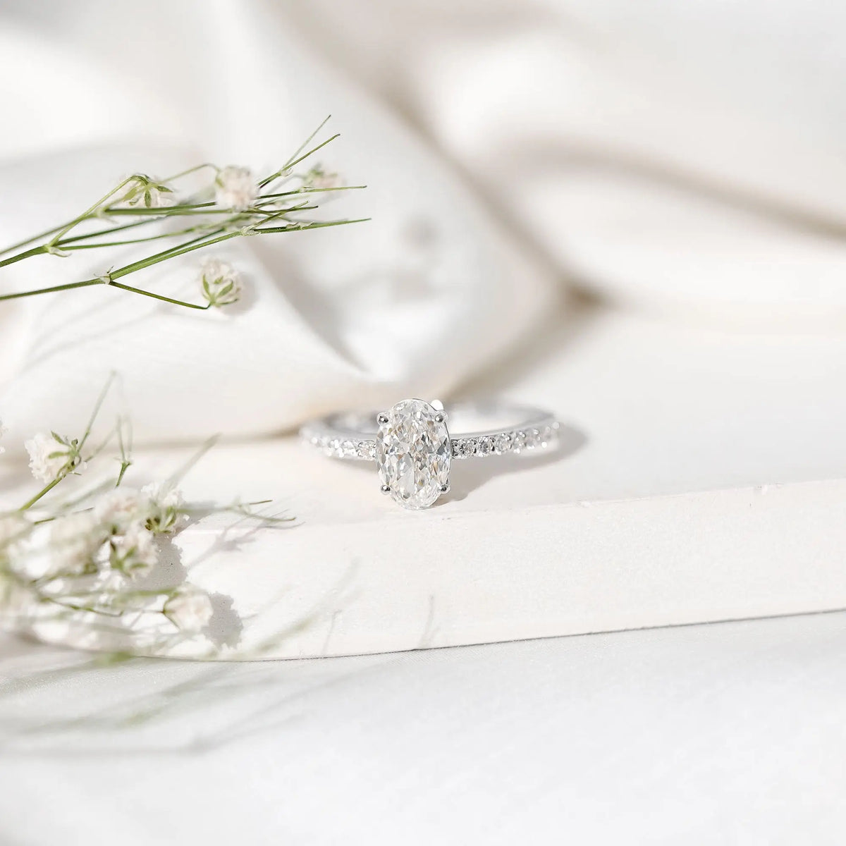 Lab Grown Diamond oval cut engagement ring with prong setting and round side stones on silver band