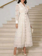 Lace Button Front Midi Dress in white featuring delicate lace fabric, long sleeves, button closure, belted waist, and a flower brooch accent