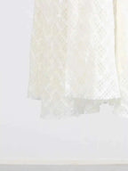White lace maxi dress hem with delicate floral pattern detail and lined polyester fabric visible on bottom edge