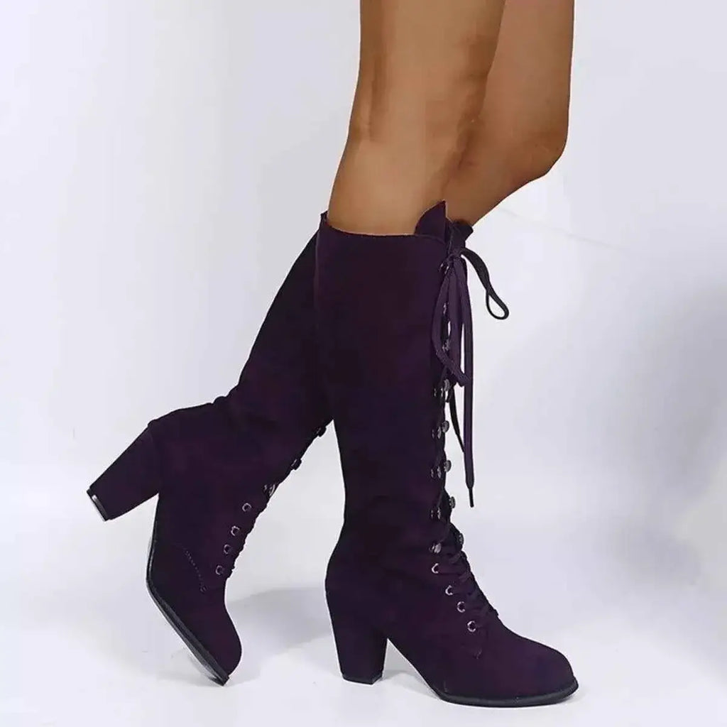 Lace Up Block Heels boots in dark purple suede with front lacing and high rubber block heels on model feet.