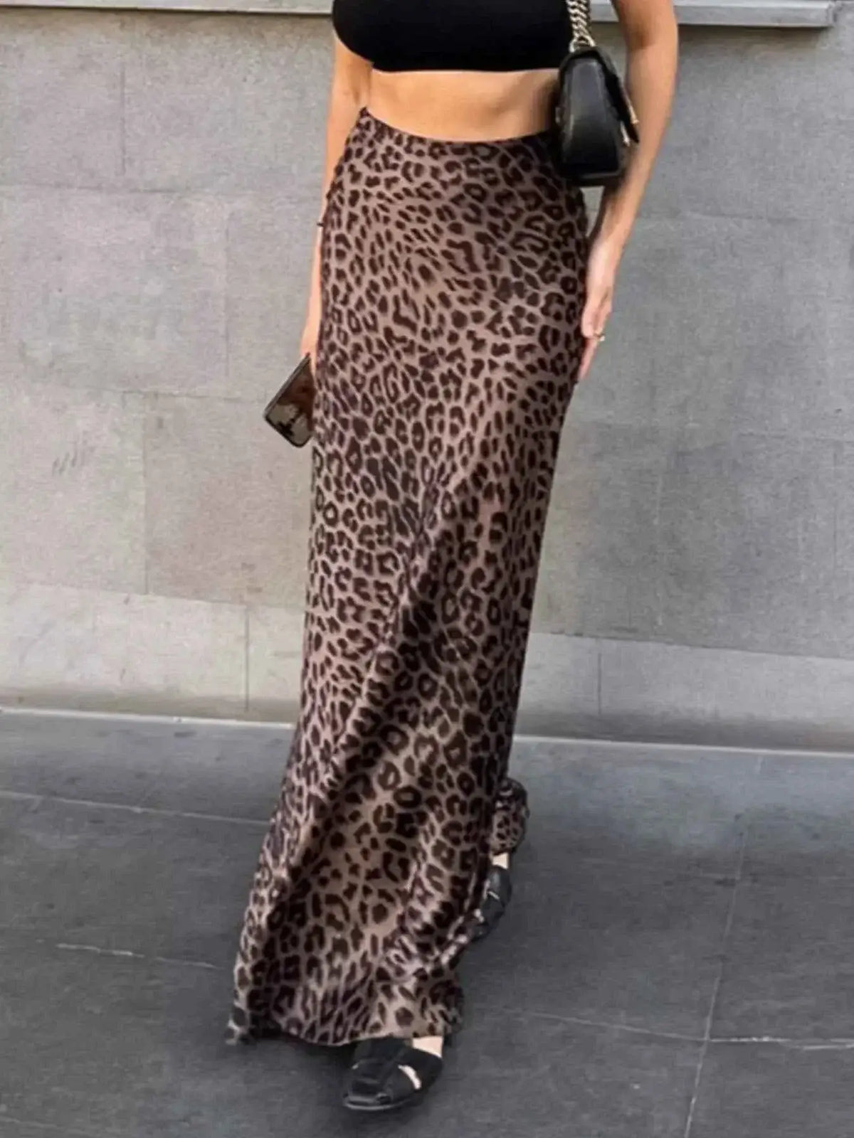 Leopard Print Maxi Skirt in brown and black polyester with zipper detail and full-length flowing fit worn with black crop top