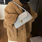 Small leopard print shoulder bag in light grey suede with a gold-tone clasp and a sleek strap design