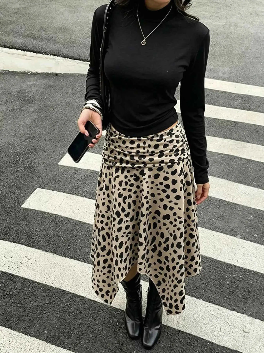 Leopard Print Skirt midi with asymmetrical hem in beige with black spots, ruched detailing, worn with black top and boots