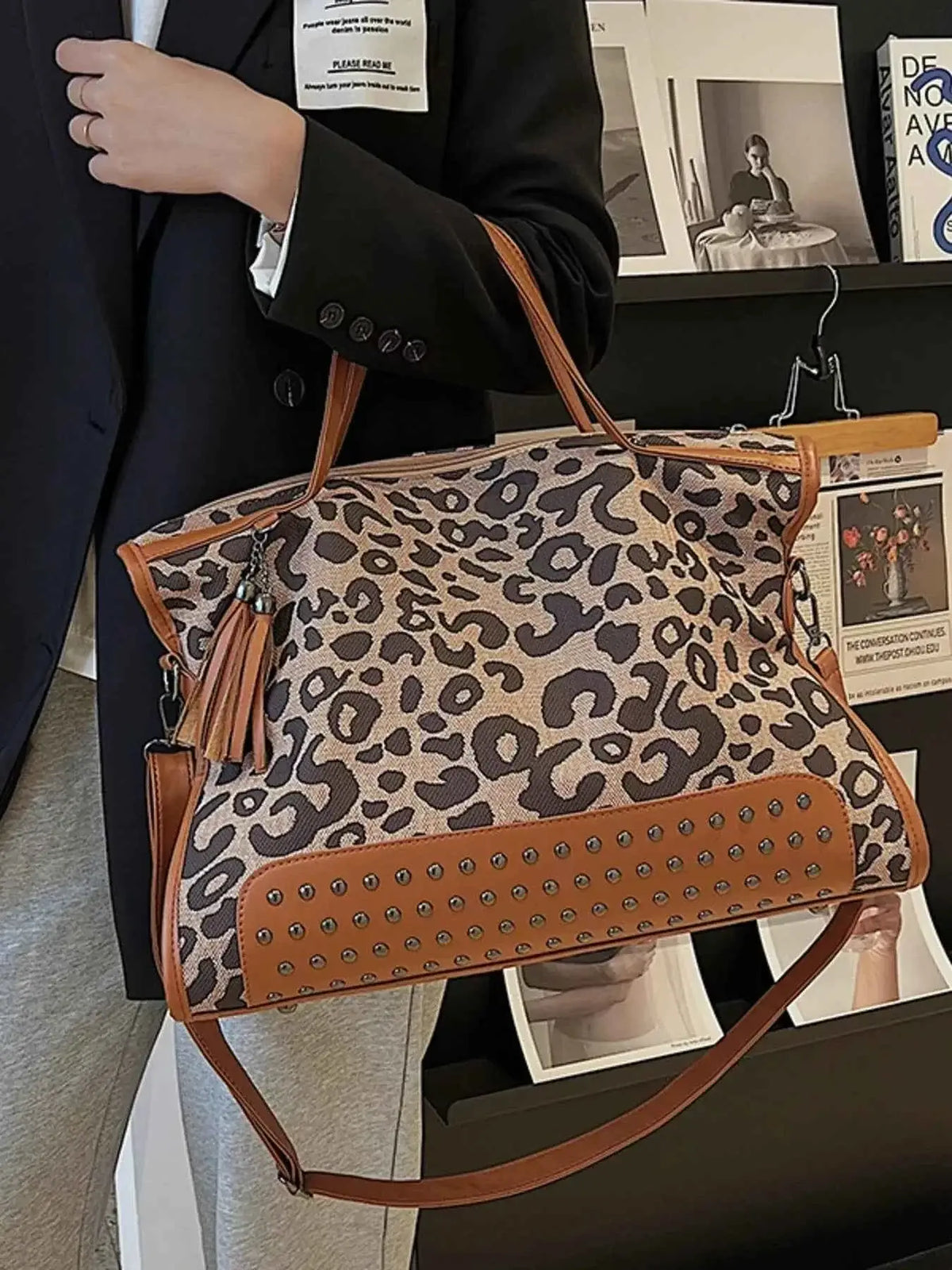 Leopard Studded Tote Bag in brown and beige faux leather with leopard print, studded base, tassel accent, and shoulder straps