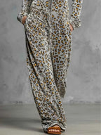 Leopard Zip-Front Hooded Jumpsuit in grey with yellow and black leopard print, featuring drawstring waist and pockets