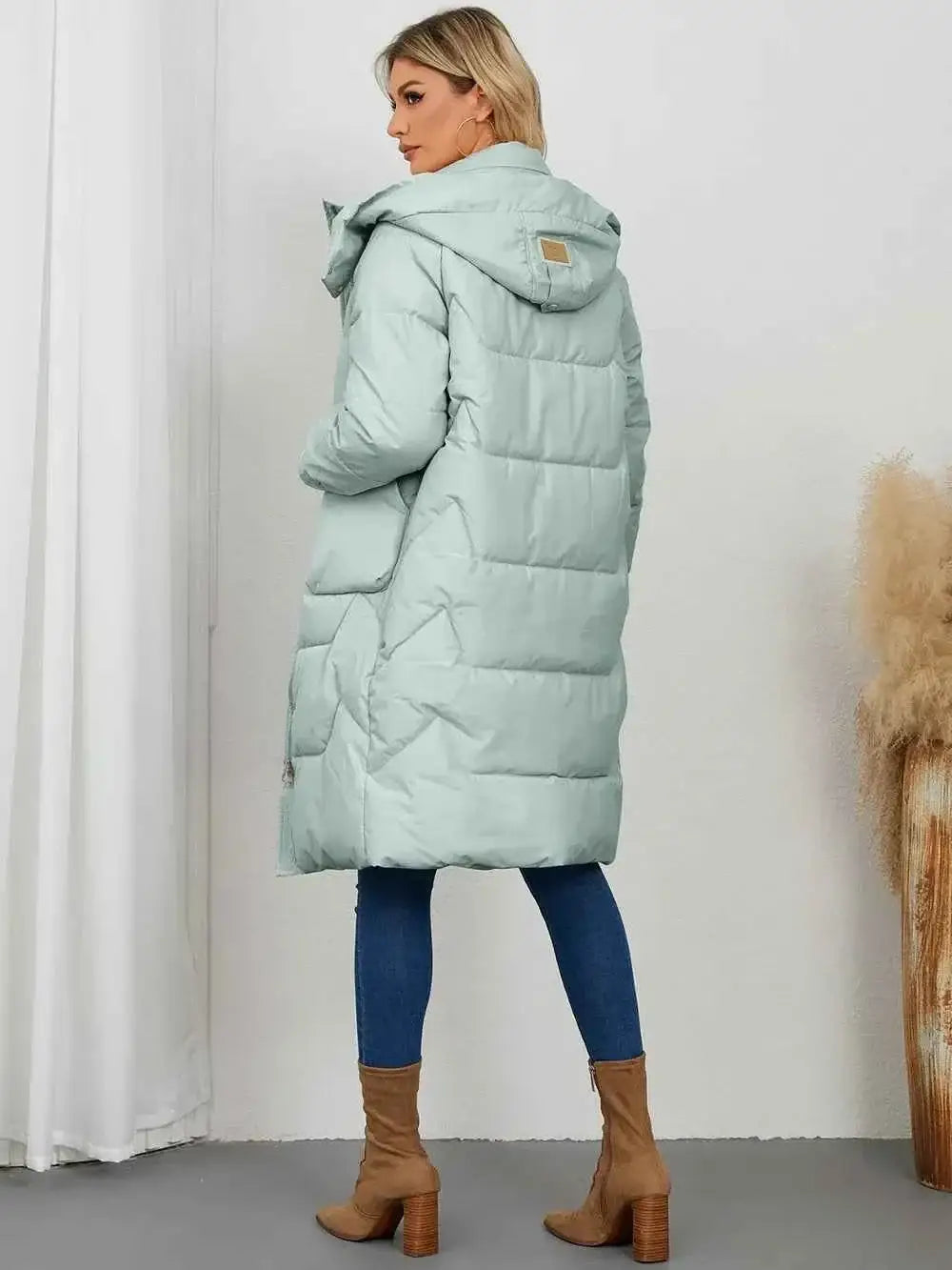 Long Sleeve Longline Hooded Winter Coat in pale green with quilted pattern, pockets, and hooded design, worn with blue jeans and brown boots