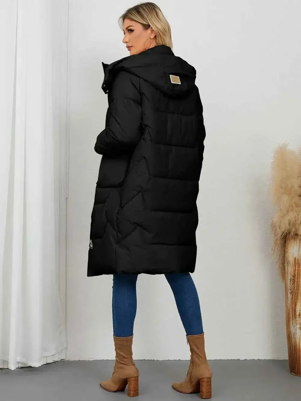 Black Long Sleeve Longline Hooded Winter Coat with padded quilting and pockets, worn with blue jeans and brown boots