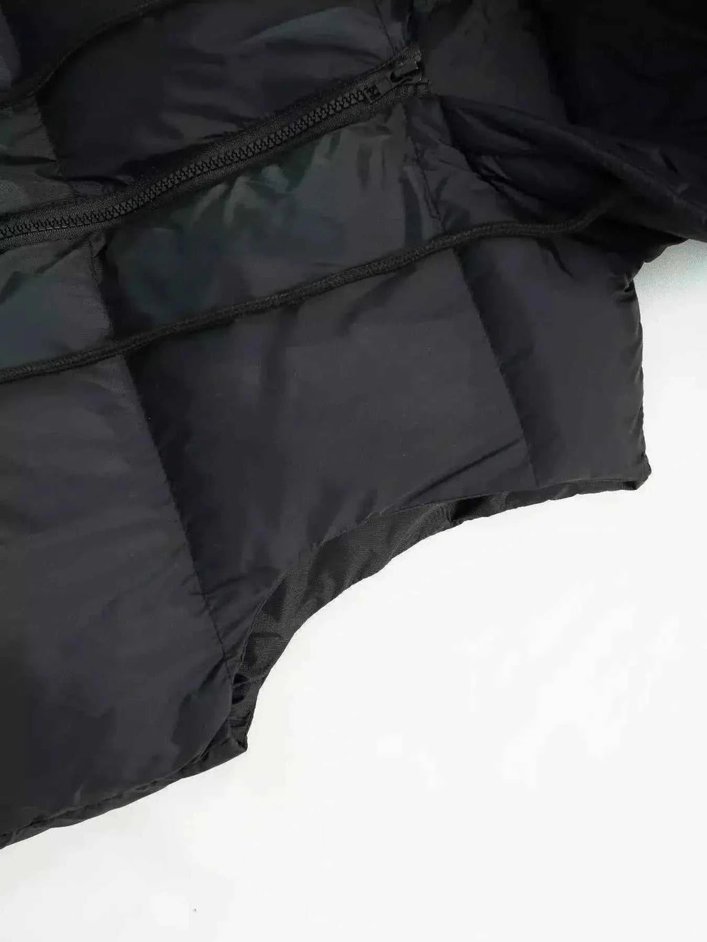 Longline Padded Hooded Vest in black polyester with pocket detail and visible zipper closure