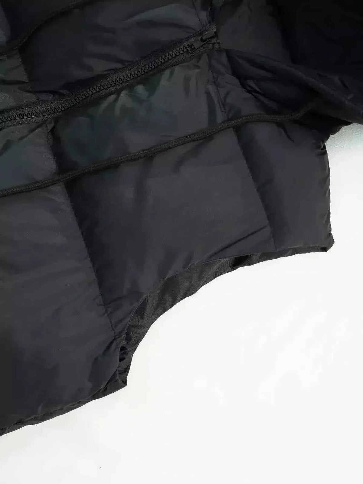 Longline Padded Hooded Vest in black polyester with pocket detail and visible zipper closure