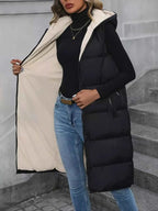 Longline Padded Hooded Vest in black polyester with pocketed zipper design and light beige interior lining worn open